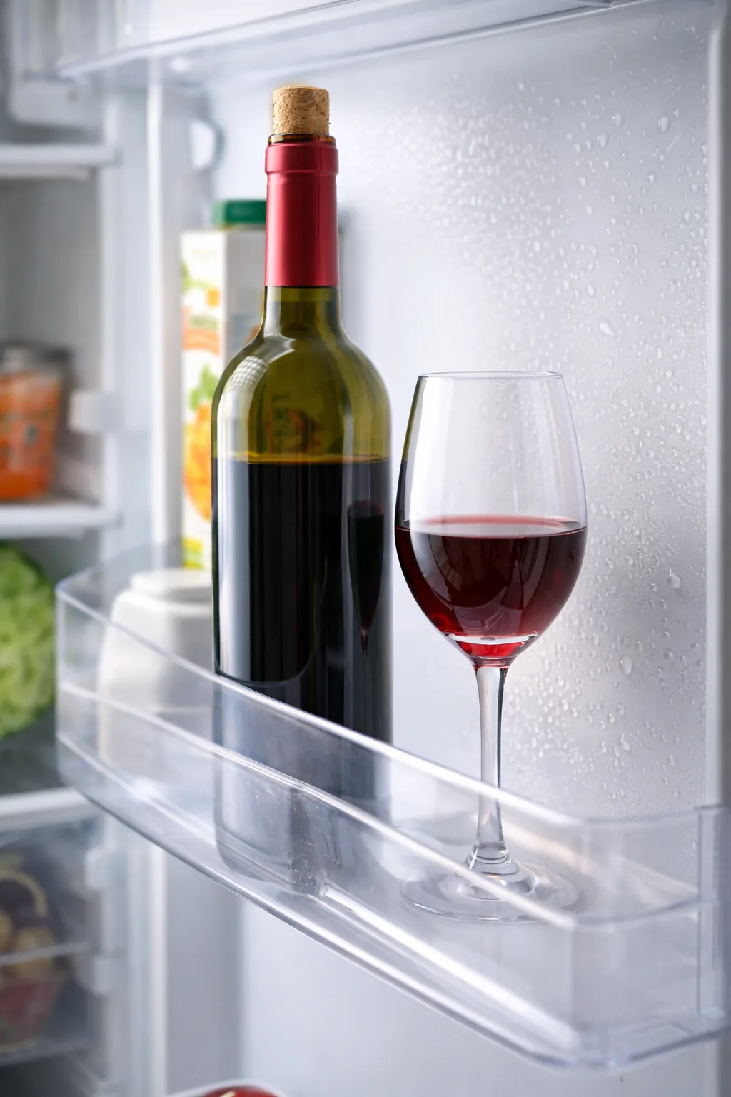 Should Red Wine Be Refrigerated? Opened bottle of red wine stored in a fridge to show when red wine should be refrigerated